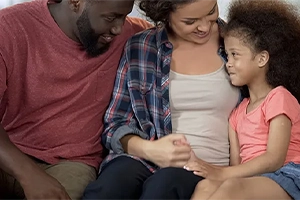 Smiling family sitting on couch together